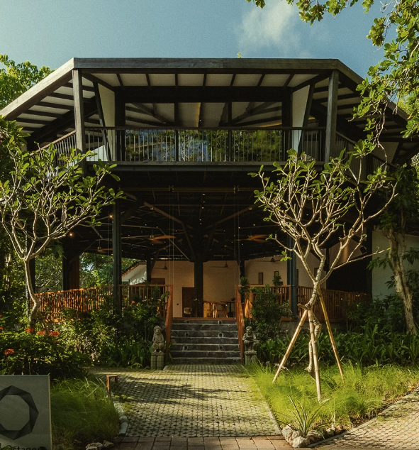 Open-air pavilion entrance with tropical gardens
