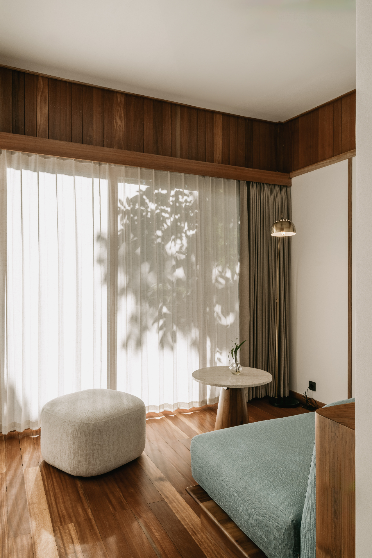 Quiet lounge corner inside the villa with soft light and timber details